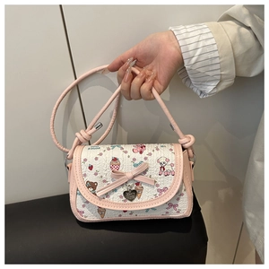 Détail du nœud rose et pendentif cœur sur le sac bandoulière imprimé papillon