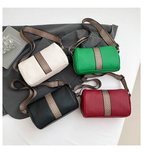 Close-up of four colors of cylindrical crossbody bags with textured faux leather