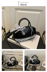 Detail of black bowling bag with metal bow and white lace trim in French romantic style