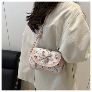 Détail du nœud rose et pendentif cœur sur le sac à bandoulière motif ours