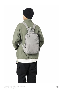 Back view of the gray minimalist nylon backpack on model showing size and soft texture
