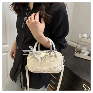 Close-up of lace edge and striped bow detail on cream white Boston shoulder bag