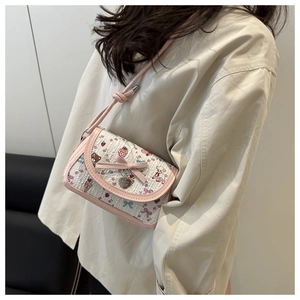 Détail du nœud rose et du pendentif cœur sur le sac à bandoulière imprimé dessin animé