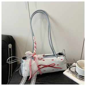 Détail d'un sac bleu avec imprimés nœuds rouges et rubans en dentelle élégants