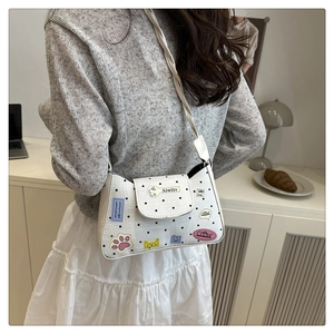 Close-up of white PU tote bag with black polka dots and colorful cartoon embroidery detail