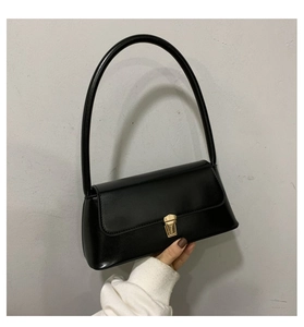 Détail du sac baguette vintage noir avec fermoir doré et finition en cuir mat