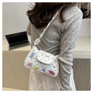 Detail of white polka dot tote bag with cute cartoon patches and woven shoulder strap