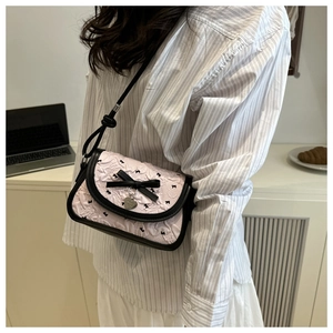 Détail du tissu plissé rose avec imprimé papillon et pendentif coeur en argent
