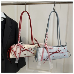 Detail of balletcore canvas shoulder bags featuring red bows and delicate lace trim