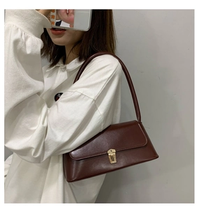 Détail du sac vintage en cuir marron avec une boucle en métal doré poli