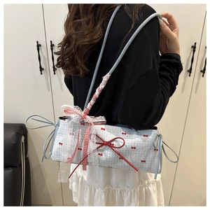 Detail of light blue bow handbag featuring red polka dots and lace trim accents