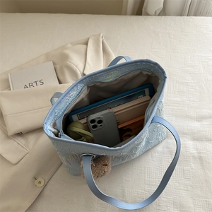 Light blue embroidered tote bag with wavy stitching, spacious interior for daily essentials