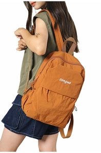 Detailed view of the large capacity orange nylon backpack featuring adjustable straps