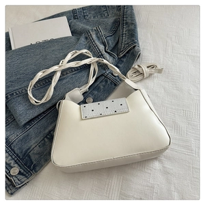 Detail of white PU shoulder bag with silver sequin flap and woven strap on denim