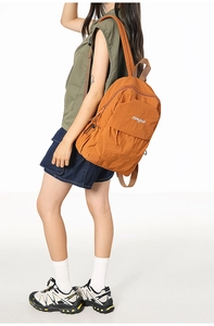 Detail view of orange-brown nylon backpack featuring songuo embroidery and sturdy zip pockets