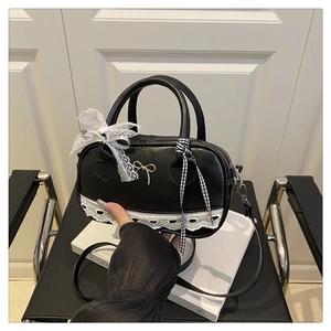 Detail of black ballet-style Boston bag with lace trim and mesh bow charm decorations