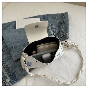 Spacious interior of polka dot shoulder bag showing space for phone and makeup