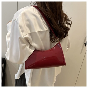 Close-up of bright red patent leather baguette bag featuring a sleek glossy finish