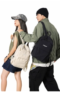 Detailed view of urban minimalist nylon backpacks in cream and black for daily commute