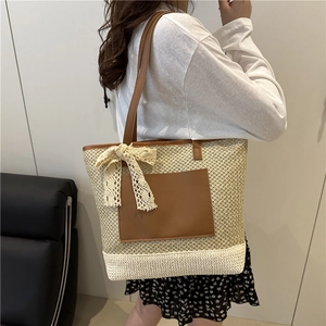 Handwoven straw tote bag with brown leather pocket and lace bow for beach vacation