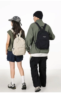 Dual back view of black and beige waterproof nylon backpacks with front zip pockets