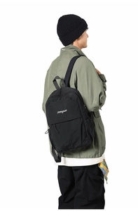 Side view of black songuo backpack showing side pockets and nylon texture on model