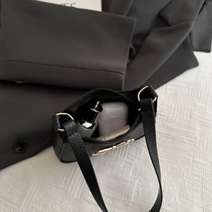 Sac à bandoulière en cuir noir grainé avec ferrures dorées et rangement intérieur
