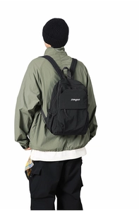 Detail showing the white songuo embroidery on high-quality black canvas backpack fabric