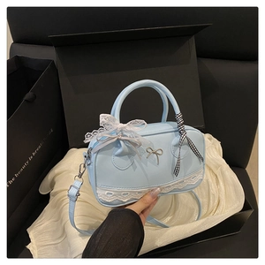 Detail of light blue handbag with silver bow, lace trim and gingham ribbon handle decoration