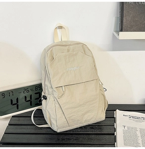 Detail shot of beige nylon backpack with songuo embroidery and textured fabric finish