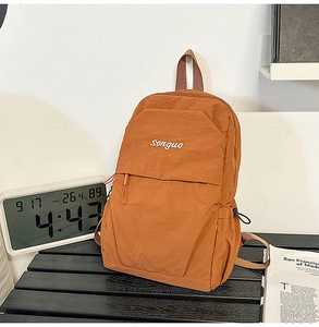 Caramel casual backpack with Songuo logo displayed on a textured wooden table