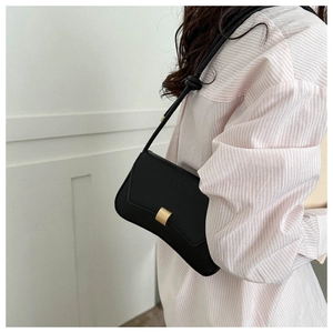 Detail of black matte leather shoulder bag with a brushed gold metal buckle closure