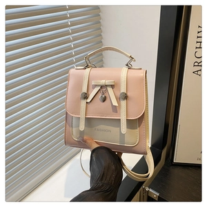 Detail of pink and white contrast leather backpack with bow and heart pendant charm