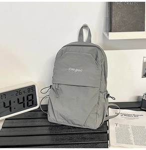 Detailed view of gray minimalist backpack with songuo logo and side drawstring pockets