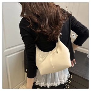 Rear view of cream white hobo shoulder bag with vertical stitching on leather surface