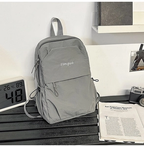 Gray nylon backpack featuring songuo embroidery and drawstring side pockets detail