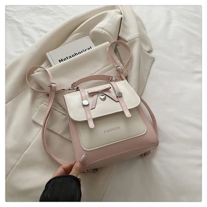 Pink and cream contrast backpack detail with bow and heart charm on white blazer