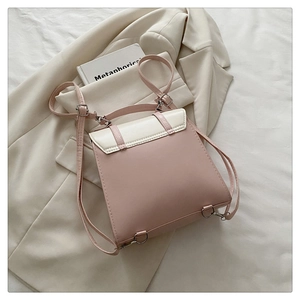 Detail view of pink and cream bicolor backpack with silver metal buckles and straps