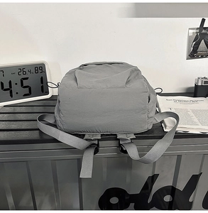 Detailed bottom view of gray nylon backpack showing reinforced straps and fabric texture