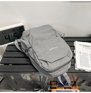 Close-up of grey lightweight nylon backpack featuring white songuo letter embroidery