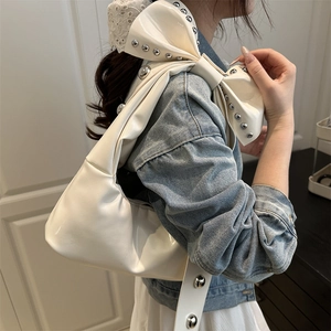 White glossy patent leather shoulder bag featuring metal rivets and a large bow detail