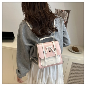 Pink and cream contrast mini backpack featuring a metal heart charm and bow detail