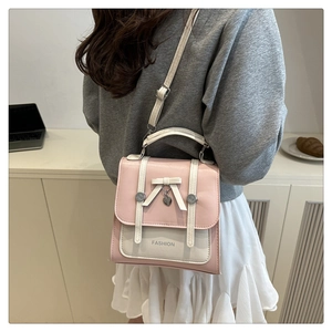 Pink and white shoulder bag with bow, heart pendant and Fashion text in a cozy setting