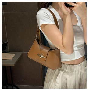 Brown leather underarm bag featuring a vintage silver star buckle for a French retro look