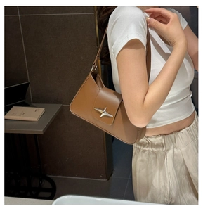 Brown leather underarm bag with minimalist flap design and a silver star metal buckle