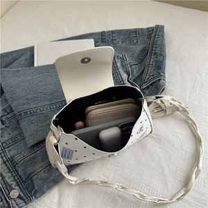 Minimalist white polka dot tote bag with blue label showing spacious interior and items