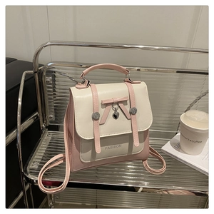 Detail of pink and white PU leather mini backpack with leather bow and heart pendant