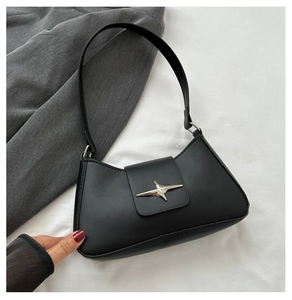 Detail of silver star metal buckle on minimalist black hobo bag with smooth matte leather