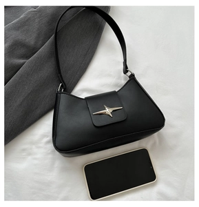 Detail of black leather shoulder bag with silver star buckle and smartphone for scale