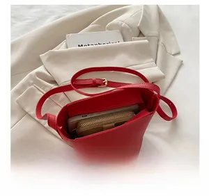 Internal capacity of the red lychee leather bucket bag showing phone and wallet